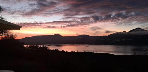 a sunset over a lake with mountains in the background at Villa Vista in Guatavita