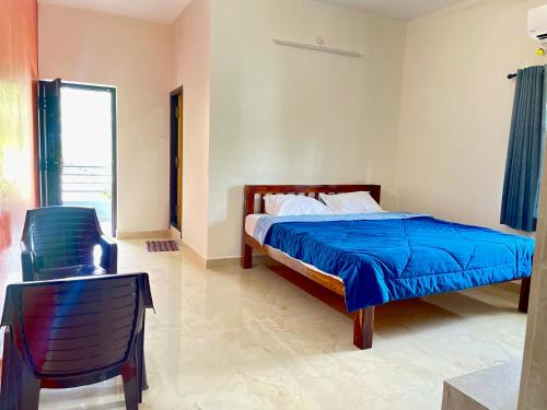 a bedroom with a bed and a chair and a table at Kamlax Villa Near Serenity Beach at puducherry in Puducherry