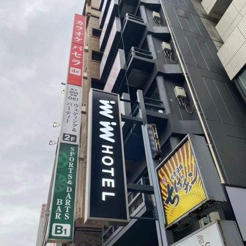 a tall building with signs on the side of it at inninn HOTEL UENO in Tokyo