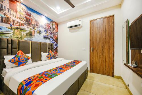 a bedroom with a bed and a painting on the wall at FabHotel Globe Inn in Ludhiana