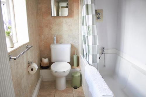 a bathroom with a toilet and a bath tub at Earl Cottage, Woodbridge in Woodbridge