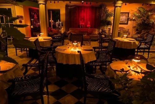 a restaurant with tables and chairs with white tablecloths at RoofTop Boutique Hotel Adults Only in Serekunda
