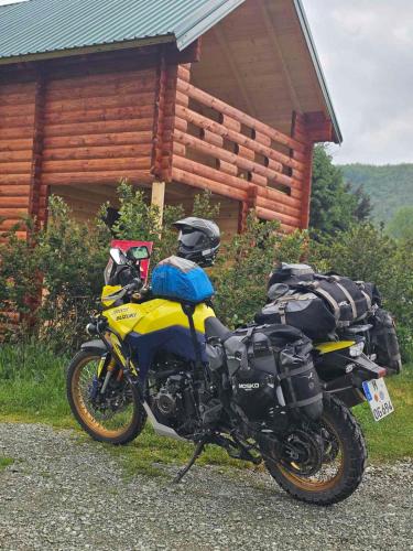 a motorcycle parked in front of a log cabin at Konaci Očeva Zemlja Vikendica i Bungalovi in Mojkovac