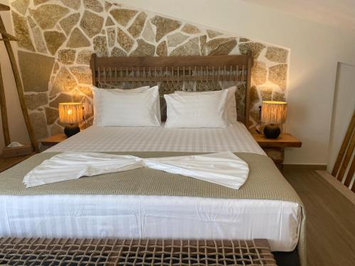 a bedroom with a bed with white sheets and two lamps at Filoxenia Sea View in Parga