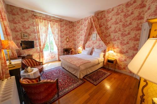 a bedroom with a bed with pink wallpaper at Le Moulin de Francueil in Francueil