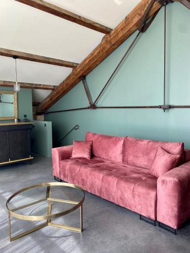 - un canapé rose et une table en verre dans la chambre dans l'établissement Loft Maison Fluide, à Aigues-Mortes