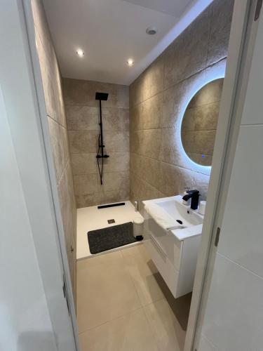 une salle de bain avec un lavabo et un miroir dans l'établissement Chez Baptiste, à Cannes