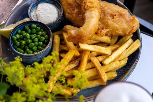 a plate of food with fish and french fries and peas at The Upper Largo Hotel & Restaurant in Lundin Links