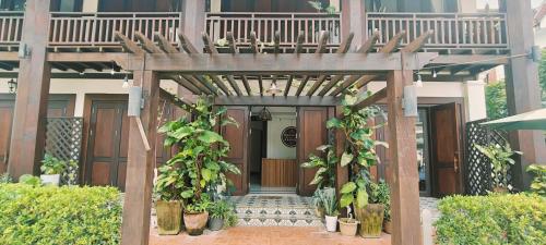 an entrance to a building with a wooden pergola at Happy hour boutiquehotel in Luang Prabang