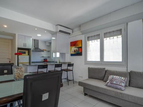 a living room with a couch and a kitchen at Los Globos Beach Studio by Hello Homes Sitges in Sitges