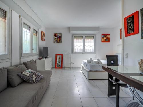 a living room with a couch and a tv at Los Globos Beach Studio by Hello Homes Sitges in Sitges