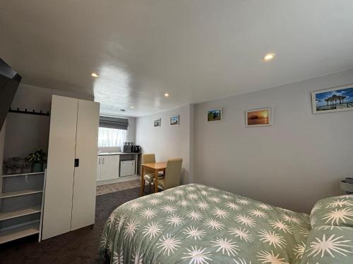 a small bedroom with a bed and a kitchen at Casa do Pedro in Portslade