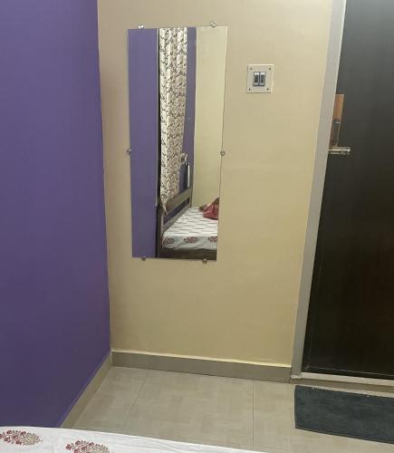 a mirror in a room with purple and yellow walls at Krishna Homestay 2BHK apartment in Chennai