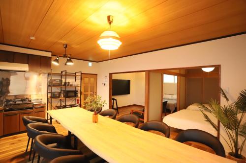 a room with a table and chairs and a bedroom at Max 11ppl Gyominsou 魚眠荘 #GS1 in Otaru