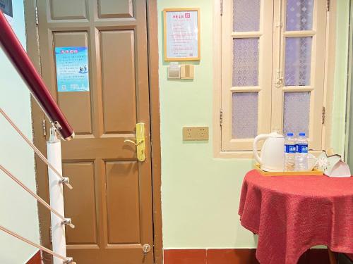 a door to a room with a table with a red table cloth at 鼓浪屿书香庄园民宿 in Xiamen