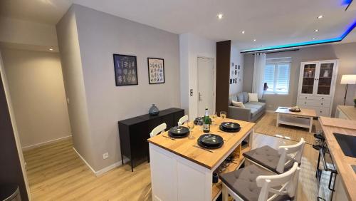 une cuisine et un salon avec une table et des chaises dans l'établissement ARKANA, appartement avec 2 places de parking, à Dole