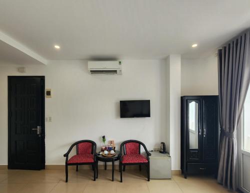 a room with two chairs and a table and a tv at THẢO AN 2 HOTEL Huế in Thôn Lại Thê