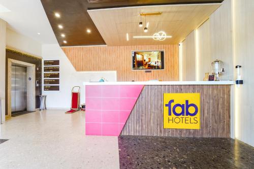 a restaurant with a pink and yellow sign on a counter at Oriva Nestlay Rooms Ramnad - Nr Golden Shopping Mall in Rāmanāthapuram