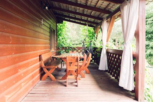 a wooden deck with a table and chairs on it at PodLaskiem SLEEP & SPA in Ateny