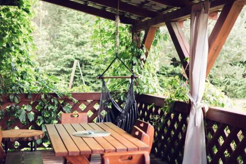 a porch with a wooden table and a hammock at PodLaskiem Sleep&Spa in Ateny