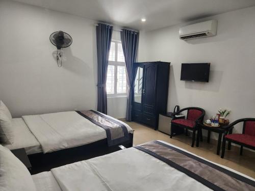 a hotel room with two beds and a tv at THẢO AN 2 HOTEL Huế in Thôn Lại Thê