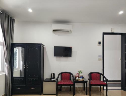 a room with two chairs and a table and a tv at THẢO AN 2 HOTEL Huế in Thôn Lại Thê