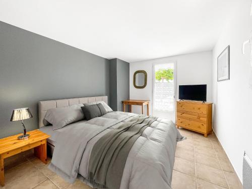 une chambre avec un grand lit et une télévision dans l'établissement Villa des Trois Îles, à La Londe-les-Maures
