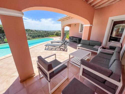 un patio avec des chaises et une piscine dans l'établissement Villa des Trois Îles, à La Londe-les-Maures