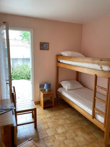 une chambre avec deux lits superposés et une fenêtre dans l'établissement Maison de vacances sur Oleron, à Saint-Georges-dʼOléron