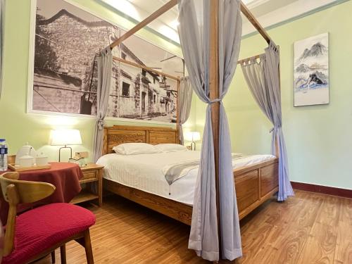 a bedroom with a canopy bed and a red chair at 鼓浪屿书香庄园民宿 in Xiamen