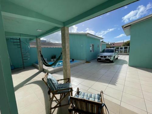 a patio with a hammock and a car in a yard at Pousada da Vovó Ideni Nova Tramandaí in Tramandaí