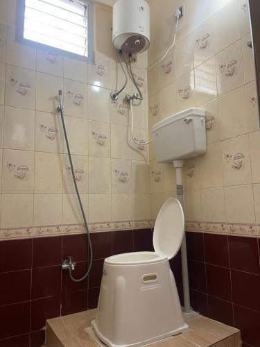 a bathroom with a toilet with a shower in it at Krishna Homestay 2BHK apartment in Chennai