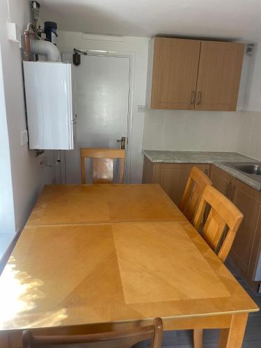 a wooden table and chairs in a kitchen at Baraka Edgware in Stone Grove