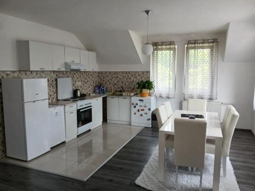 a kitchen with white appliances and a table and chairs at Apartman_Alex in Pale
