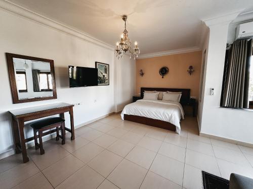 a bedroom with a bed and a table and a mirror at Riad Dar Achaach in Tetouan