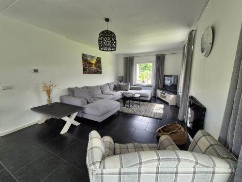 a living room with two couches and a table at De Eekhoorn in Tzummarum
