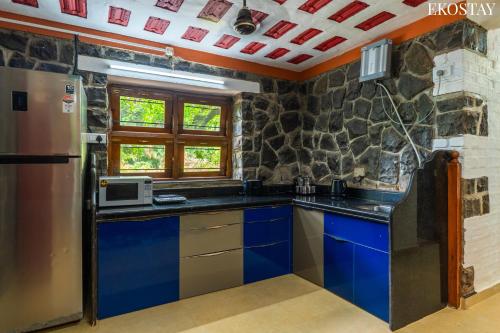 a kitchen with blue cabinets and a refrigerator at EKOSTAY- Caribbean Villa in Panvel