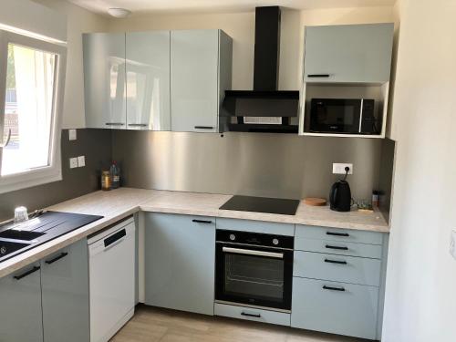 une cuisine avec des armoires blanches et un four à plaques de cuisson dans l'établissement Chambre dans une maison en Colocation proche paris et Disney Room in shared house, à Vaires-sur-Marne