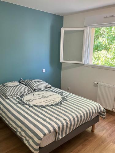 Ce lit se trouve dans une chambre dotée d'un mur bleu et d'une fenêtre. dans l'établissement Chambre dans une maison en Colocation proche paris et Disney Room in shared house, à Vaires-sur-Marne