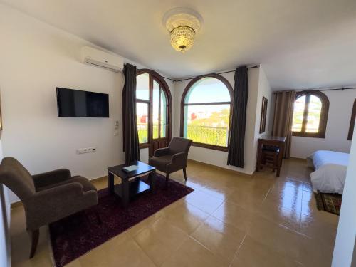 a bedroom with a bed and two chairs and a television at Riad Dar Achaach in Tetouan