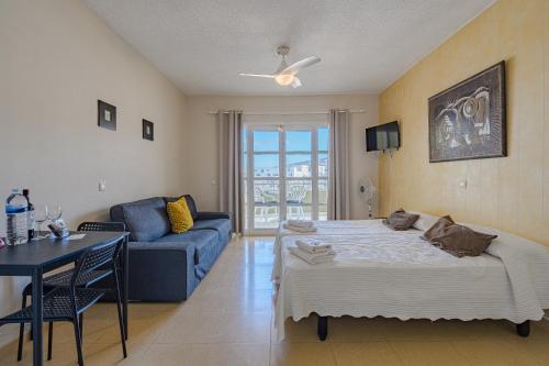 阿德耶Apartamentos ORLANDO en Costa Adeje的客厅配有床和蓝色沙发