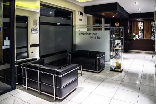a salon with black leather seats and a white barber shop at Acca Palace AA Hotels in Milan