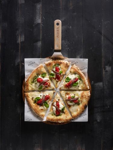 a pizza sitting on top of a wooden table at Crowne Plaza Changi Airport by IHG in Singapore
