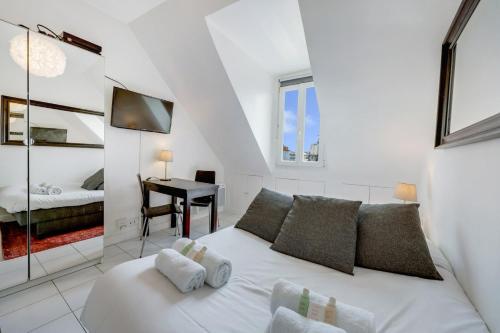 - un salon blanc avec un lit et un bureau dans l'établissement Paris Marais Rosiers, à Paris