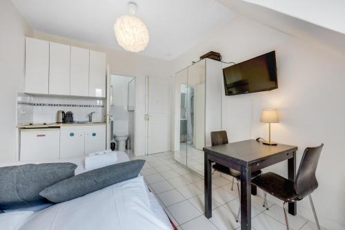 un salon avec un canapé et une table et une cuisine dans l'établissement Paris Marais Rosiers, à Paris