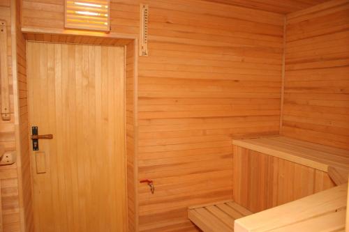 a small wooden sauna with a wooden door at Naiza Guesthouse and Apartments in Jūrmala