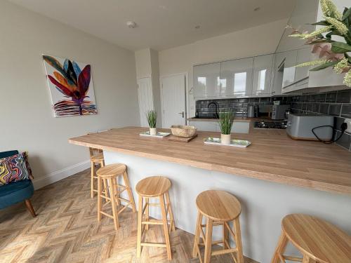 a kitchen with a counter with stools at Holywell Stays in Old Town