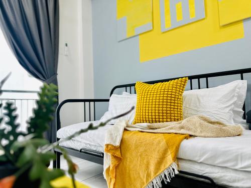 a bed with a yellow blanket and pillows on it at New The Sun Homestay at Sg Nibong nearby Queensbay or PISA or FTZ Bayan Lepas HENG in Bayan Lepas