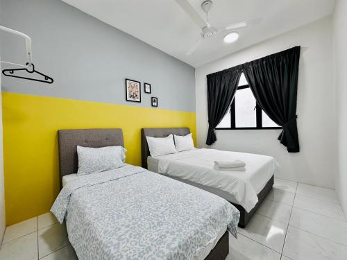 two beds in a room with yellow and white at New The Sun Homestay at Sg Nibong nearby Queensbay or PISA or FTZ Bayan Lepas HENG in Bayan Lepas