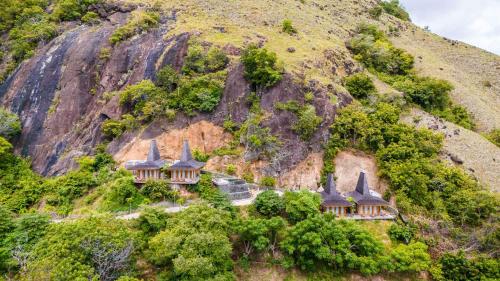 a group of houses on the side of a mountain at Menjaga Bay in Labuan Bajo